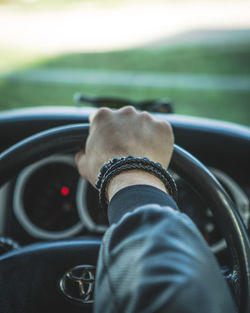 Cropped hand of man driving car