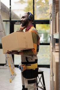 Rear view of man holding box