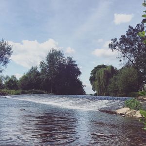 River amidst trees against sky