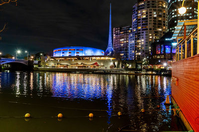 Illuminated buildings in water at night