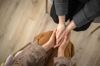 Low section of woman holding hands