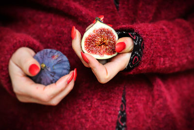 Midsection of woman holding fig