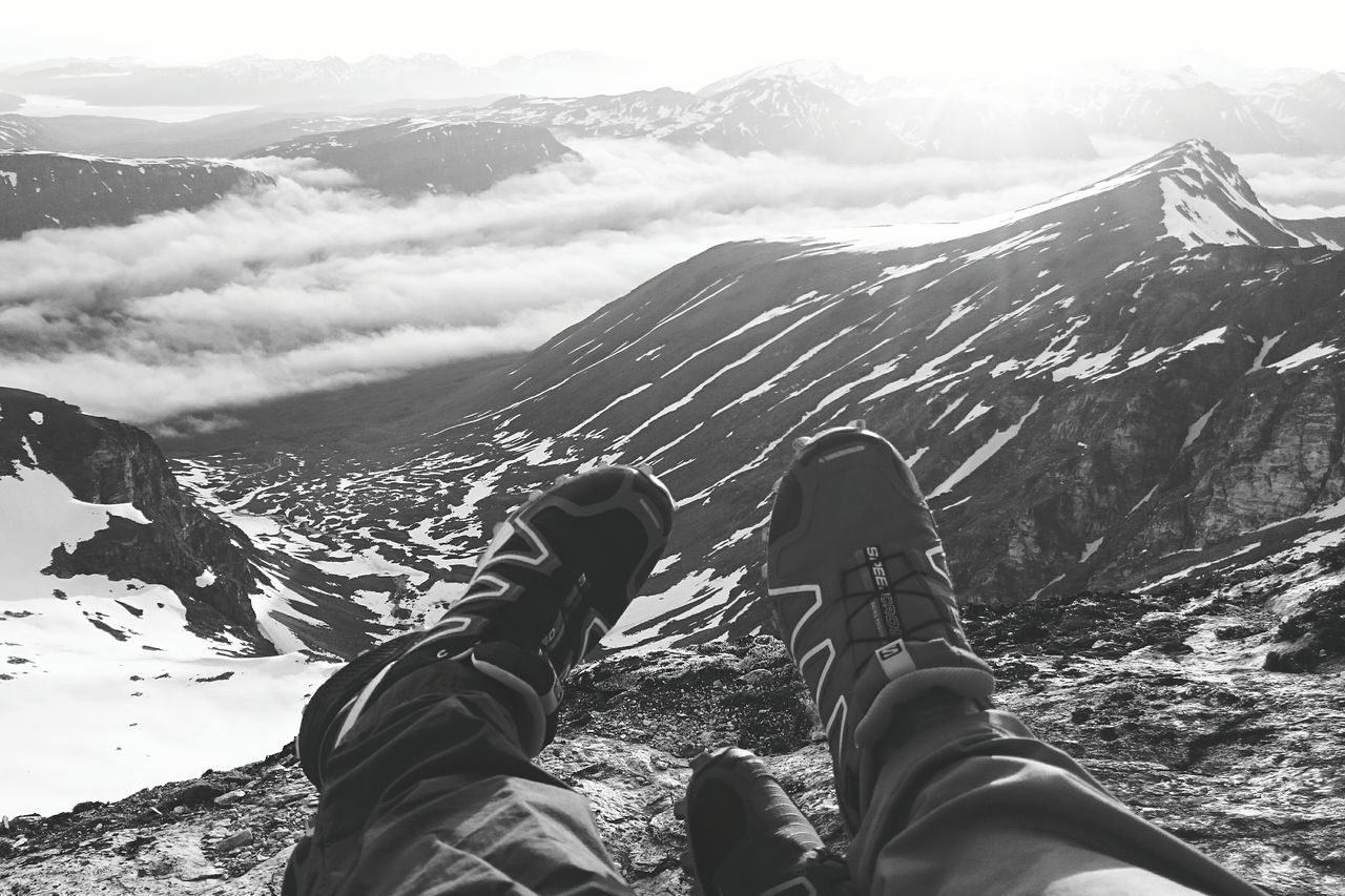 LOW SECTION OF MAN STANDING ON SNOW COVERED MOUNTAIN