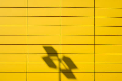 Full frame shot of yellow shadow on tiled floor