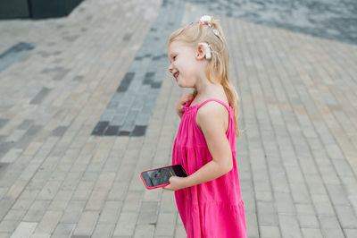 Young woman standing on footpath