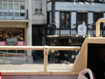 Close-up of railing by railroad track in city