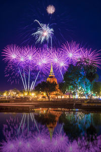 Firework display over lake at night