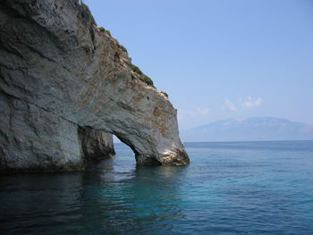 Scenic view of rock formation in sea against sky