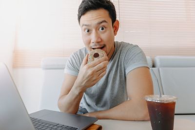 Portrait of young woman using laptop at home