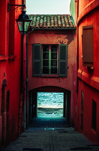 Vibrant red building, inviting gate to the sea. ideal for travel, coastal, and summer projects.