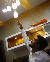 Low angle view of boy holding illuminated lighting equipment at home