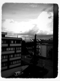 Buildings in city against cloudy sky