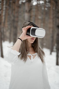 Young woman using phone while standing on camera