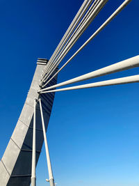 Low angle view of suspension bridge against clear blue sky