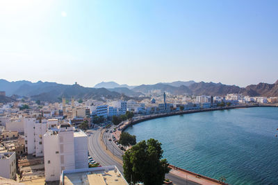 High angle view of city by sea against sky
