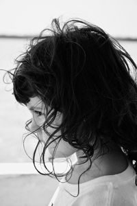 Side view of girl with messy hair standing by wall