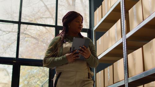 Portrait of young woman standing against building