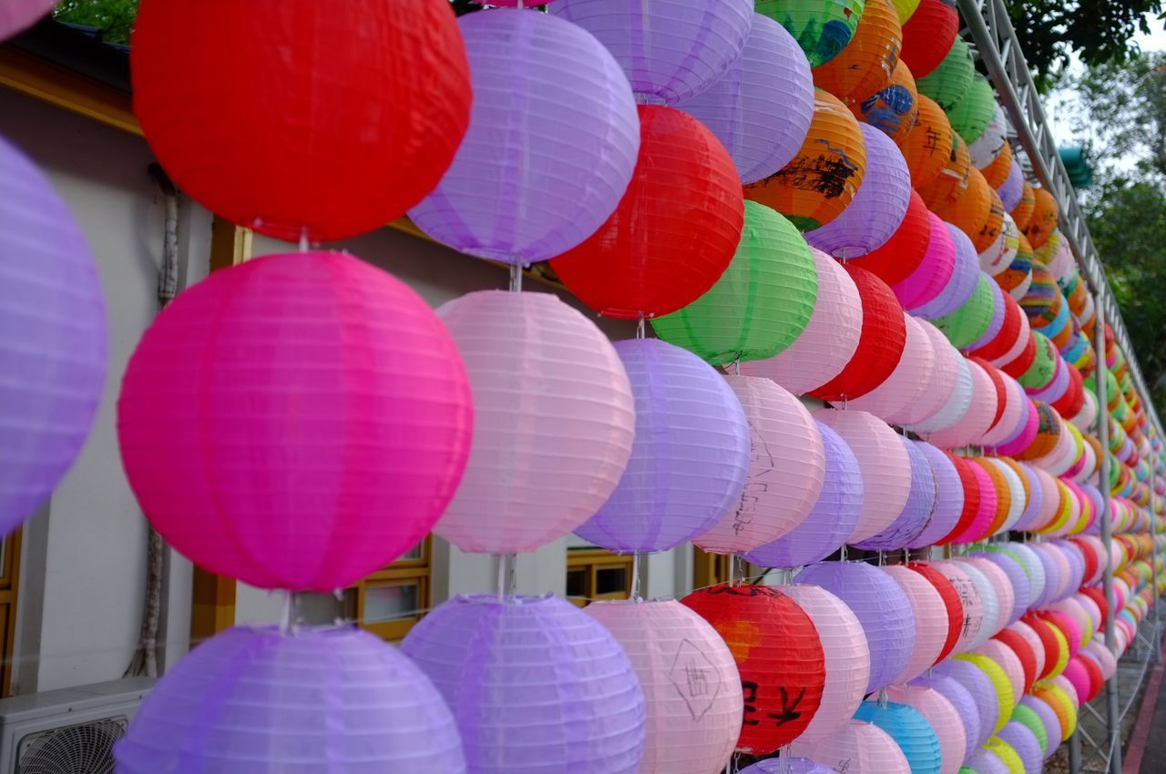 large group of objects, multi colored, lantern, hanging, celebration, chinese lantern, tradition, no people, balloon, event, decoration, lighting equipment, chinese new year, abundance, traditional festival, in a row, low angle view, festival, toy, day, chinese lantern festival, repetition, outdoors, pink, variation, red, holiday, arrangement