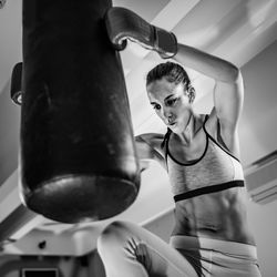 Woman practicing with punching bag in boxing rink