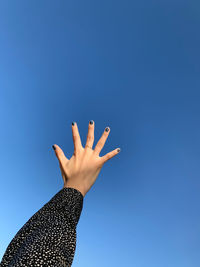 Midsection of woman against blue sky