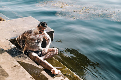 High angle view of man sitting at sea shore