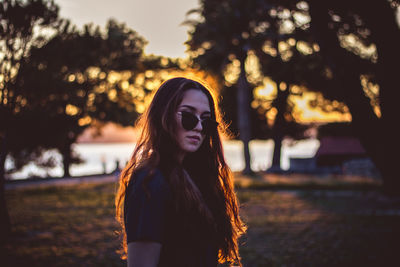 Portrait of smiling young woman against sky during sunset