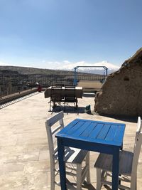 Empty chairs and tables against clear blue sky