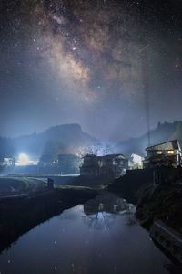 Scenic view of lake against sky at night