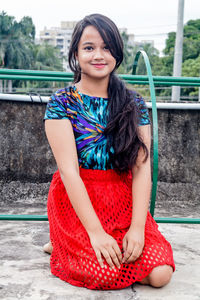 Portrait of young woman sitting outdoors