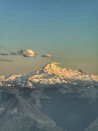 Scenic view of snowcapped mountains against sky during sunset