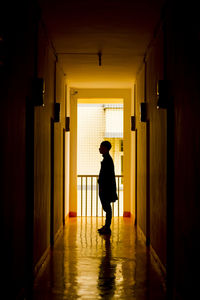 Full length of silhouette man walking in illuminated building
