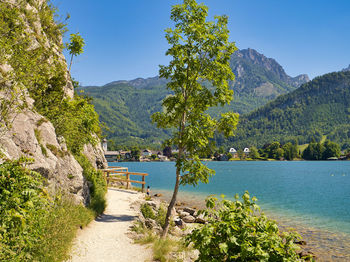 Scenic view of river by mountains against sky
