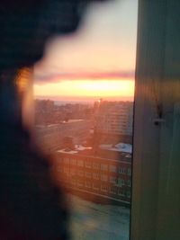 Cityscape seen through window at sunset