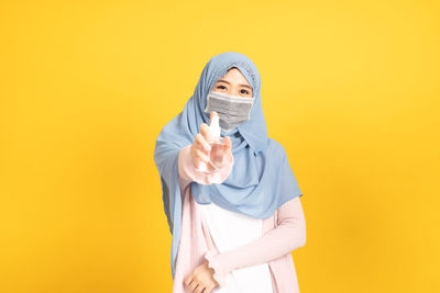 Portrait of a woman against yellow background