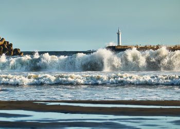 Wave crashing scenic view of sea against clear sky