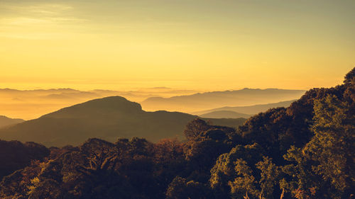 Scenic view of silhouette mountains against orange sky