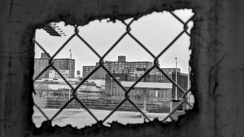 Buildings seen through chainlink fence