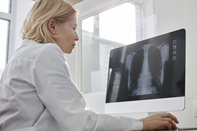 Doctor analyzing x-ray image on desktop pc in clinic