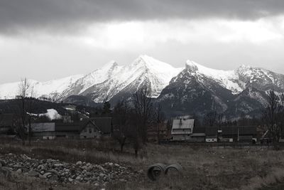 Houses on snowcapped mountains against sky