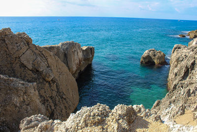 Scenic view of rocks in sea against sky