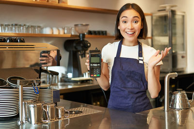 Portrait of young woman standing in cafe