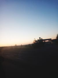 Car on road against clear sky during sunset