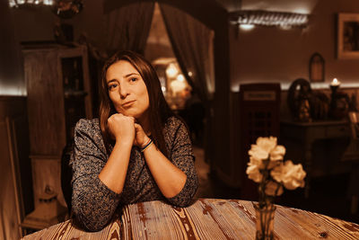 Emotions of lonely woman at cafe at the table drinking tea in the evening at cafe romantic light