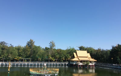 Built structure by river against clear sky