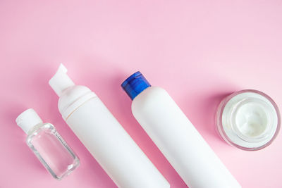 Set of cosmetics for skin care and cleansing on a pink background. 