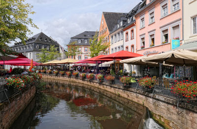 Canal amidst buildings in city against sky