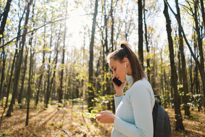 Beautiful girl uses phone for fitness or yoga.