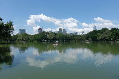 Scenic view of lake by buildings against sky