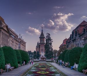 People on street amidst buildings against sky