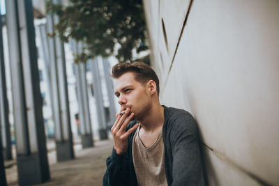 Young man smoking cigarette outdoors